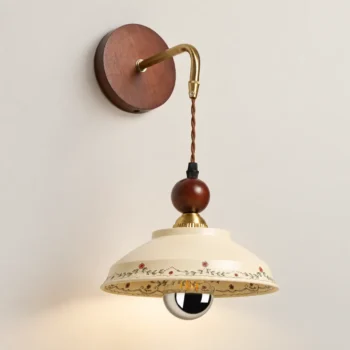 Vintage floral ceramic wall sconce with hand-painted cream shade, wood backplate and brass hanging arm